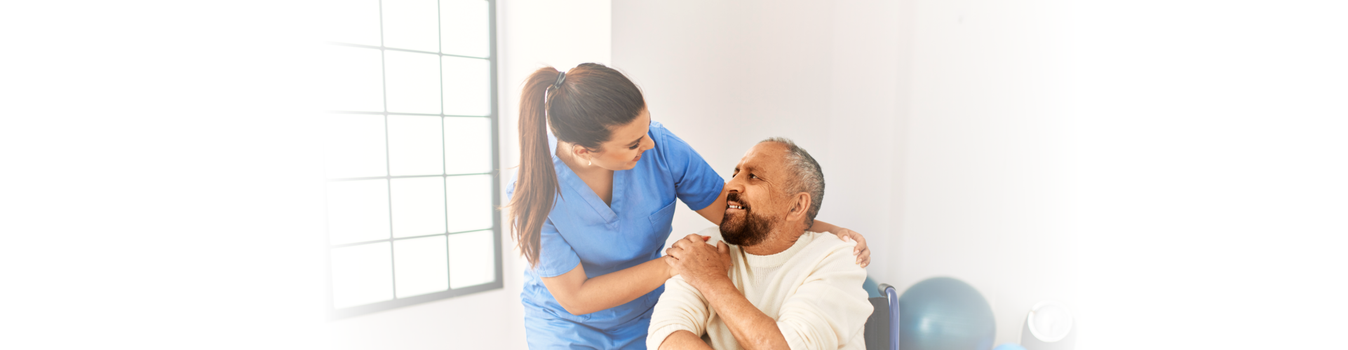 Happy older patient on wheelchair with female nurse